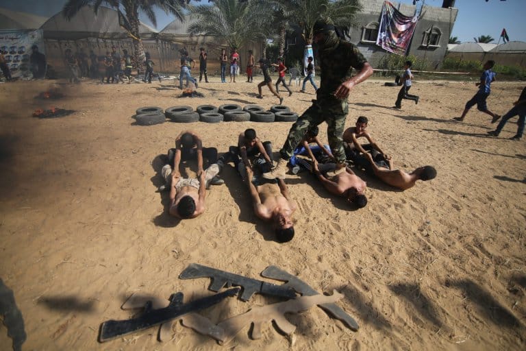 epa05423128 Palestinian boys take part in a military-style summer camp being held by the Islamic Jihad movement during the youngsters' summer school vacation in Khan Younes town, in the southern Gaza Strip, 13 July 2016. Thousands of youngsters between the age of six and 16 can participate in the summer camp where they receive military as well as religious training. EPA/HATEM OMAR