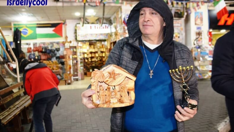 In Bethlehem bus station man asks tourists to buy menorah or creche before Christmas holiday
