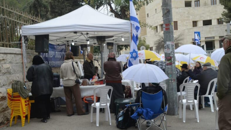photo vigil, image women in green, picture sitting in rain