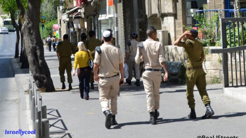 Israeli soldiers walking near Arab girl