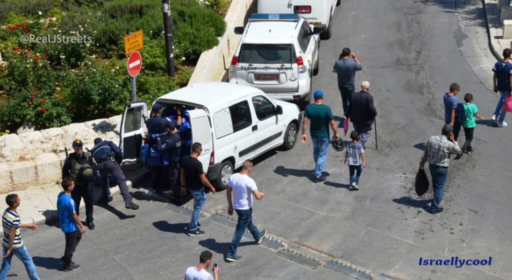 Muslims walk by Israeli Police