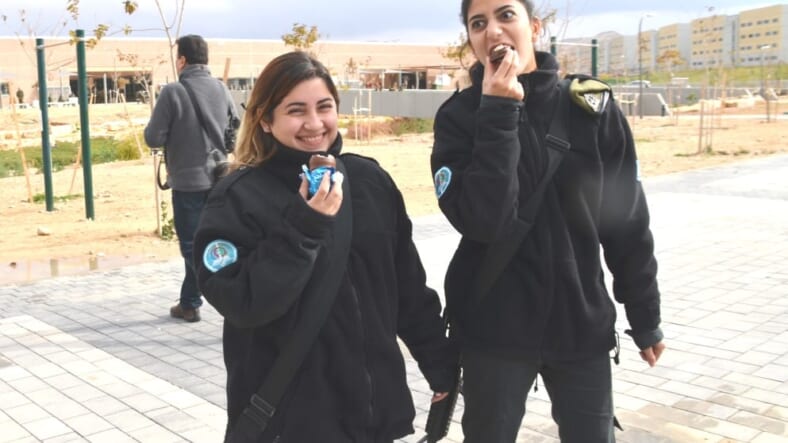 Two female Israeli soldiers on base eating a Crembo