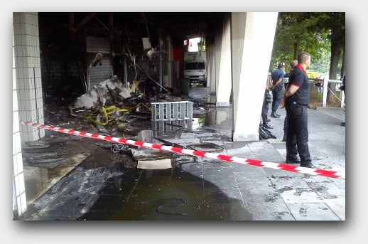 Police guarded the burned-out remains of a pharmacy attacked in the riots. Photo: The Local