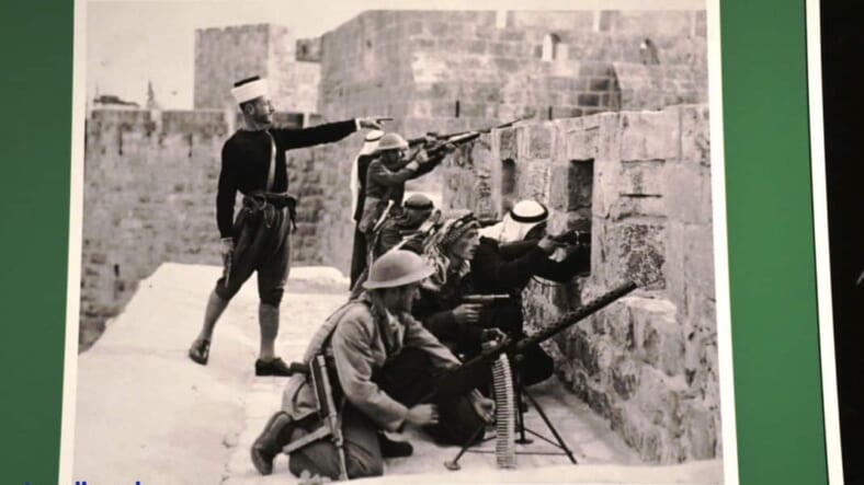 Jordanian posed on top of walls of Old City to shoot below, 1948- Jerusalem