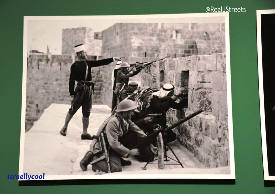 Jordanian posed on top of walls of Old City to shoot below, 1948- Jerusalem