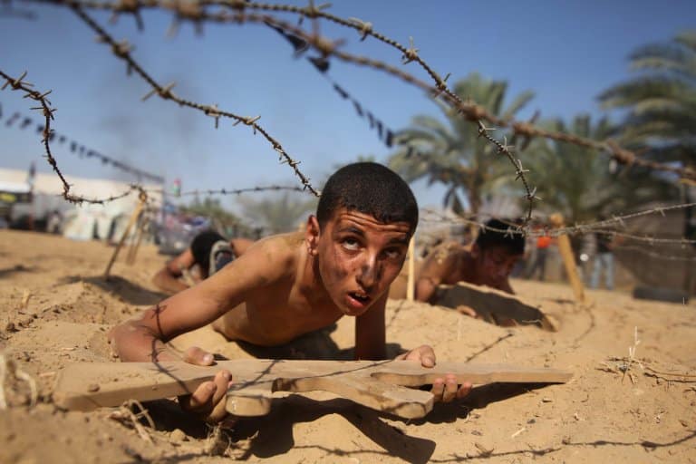 epa05423129 A Palestinian boy takes part in a military-style summer camp being held by the Islamic Jihad movement during the youngsters' summer school vacation in Khan Younes town, in the southern Gaza Strip, 13 July 2016. Thousands of youngsters between the age of six and 16 can participate in the summer camp where they receive military as well as religious training. EPA/HATEM OMAR