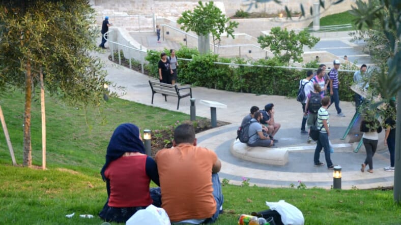 Muslim amn and woman sit in Teddy Park Jerusalem