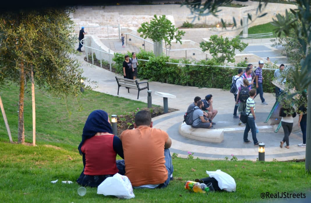 Muslim amn and woman sit in Teddy Park Jerusalem