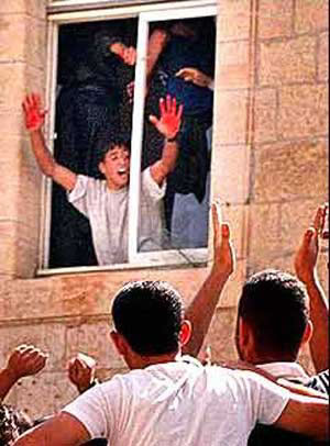 Bloody hands at the window in Ramallah after slaughtering a Jew