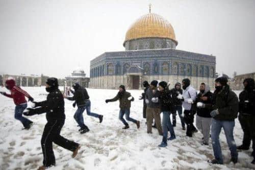 Palestinians play with snow outside the Dome of the Rock at the Al-Aqsa mosque compound in Jerusalem on January 10, 2013